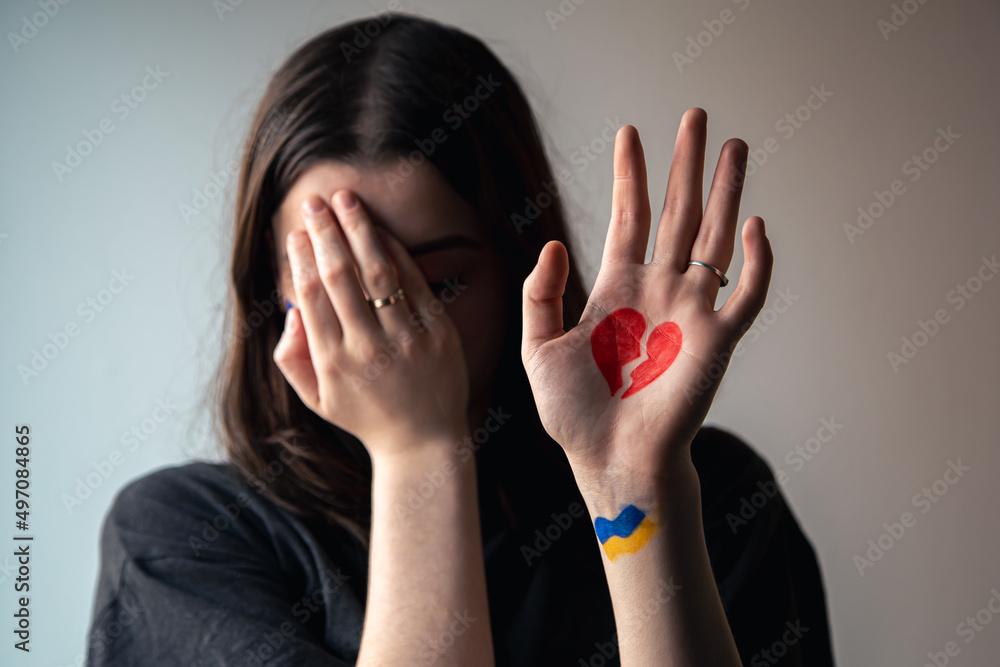 Ukrainian girl with a broken heart drawn on her hand, pain for Ukraine. Ukrainian girl with a broken heart drawn on her hand, pain for Ukraine.