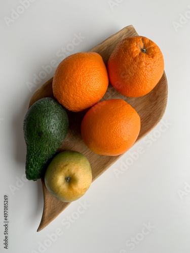 Fruit on a wooden plate on a white table