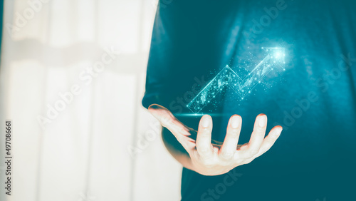 Businessman or trader showing growing virtual hologram or low polygon graph on hand. Strategic planning of business growth  stock market  digital assets  and investment finance.