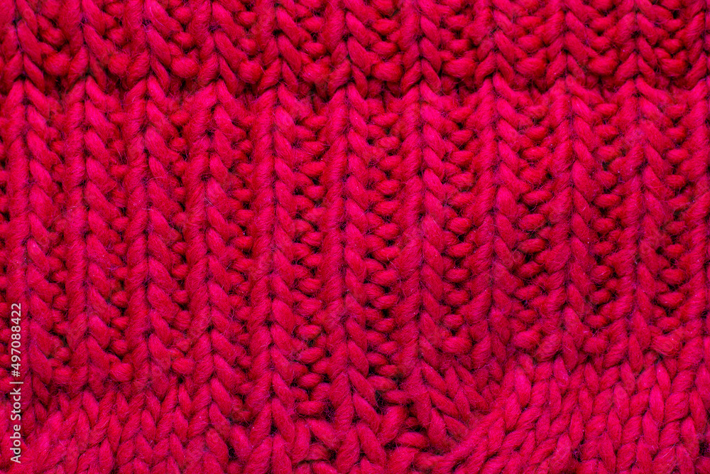 Red knitted woolen background for your design. Knit fabric pattern of sweater