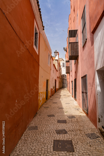Fototapeta Naklejka Na Ścianę i Meble -  narrow pedestrian alley leading through tall colorful pink houses
