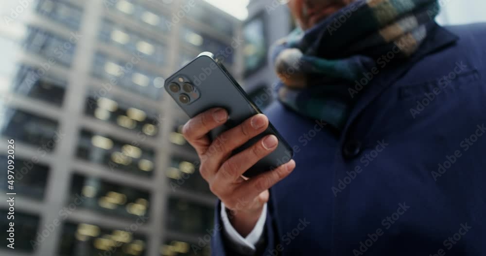 A man uses a mobile phone, standing in business center of the city A man uses a mobile phone, standing in business center of the city