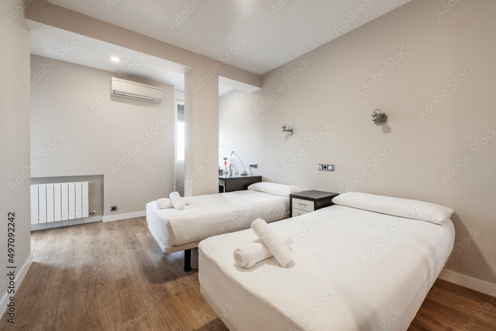 Fotka „Bedroom with two separate beds, rolled towels on the beds, dark ...