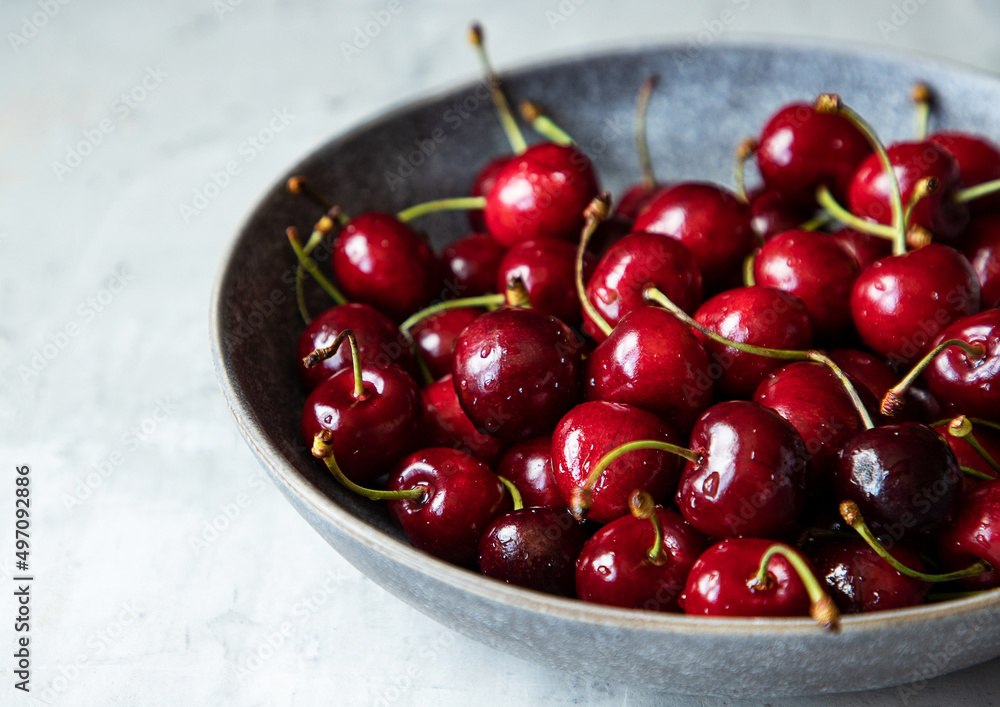 Plate of fresh raw cherries. Close up of bright red cherry with drops of water. Healthy eating concept. Vitamin rich diet. Plate of fresh raw cherries. Close up of bright red cherry with drops of water. Healthy eating concept. Vitamin rich diet.