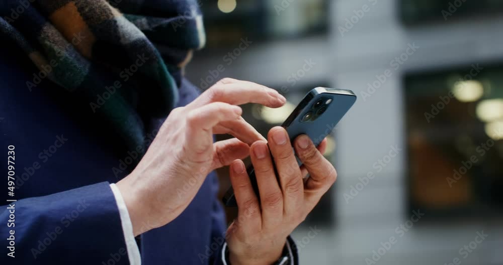 A man uses a mobile phone, standing in business center of the city A man uses a mobile phone, standing in business center of the city
