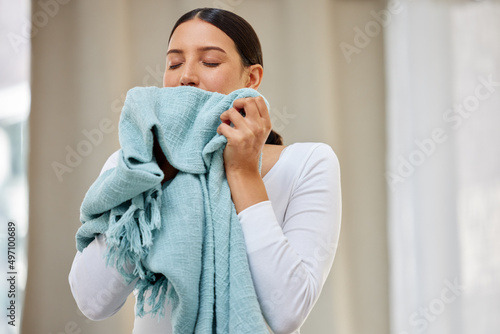This smell should be bottled. Shot of a young woman smelling freshly cleaned laundry.