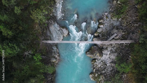Wallpaper Mural Aerial drone zoom in shot of aesthetic suspension old wooden bridge over epic mountain rocks and waterfall river. Scandinavian or northern hiking culture. Healthy adventure in outdoors Torontodigital.ca