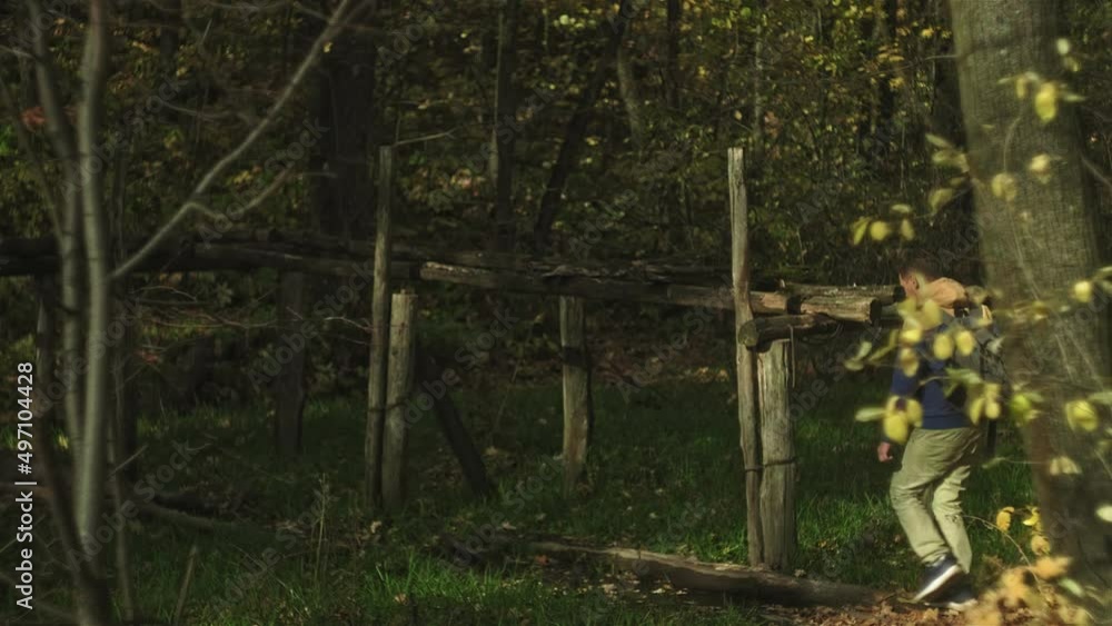 A mature man tourist traveler with a backpack walks in the autumn forest near the river A mature man tourist traveler with a backpack walks in the autumn forest near the river