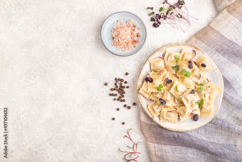 Dumplings with pepper, herbs, microgreen on gray concrete. Top view, flat lay, copy space.