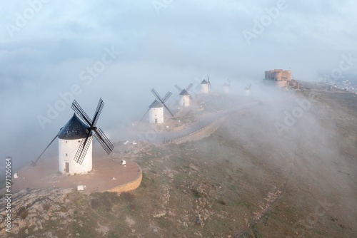 Typical old white Spanish windmills (Molinos appearing in Don Quijote) surrounded by a dry landscape in Consuegra, Toledo. Castilla la Mancha, Spain.