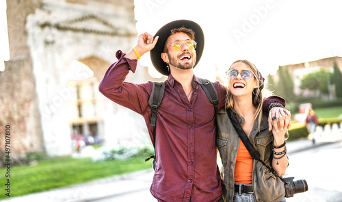 Happy boyfriend and girlfriend in love having genuine fun walking at old city center - Wanderlust life style and travel vacation concept with tourist couple on sightseeing exploration - Warm filter