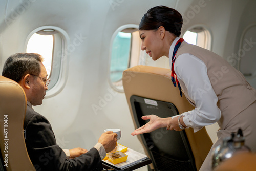Fényképezés Air hostess or cabin crew serve dessert and cake to the passenger or business man