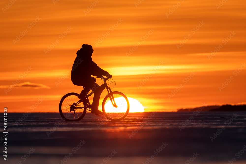 Fototapeta premium Silhouette of a cyclist at sunset