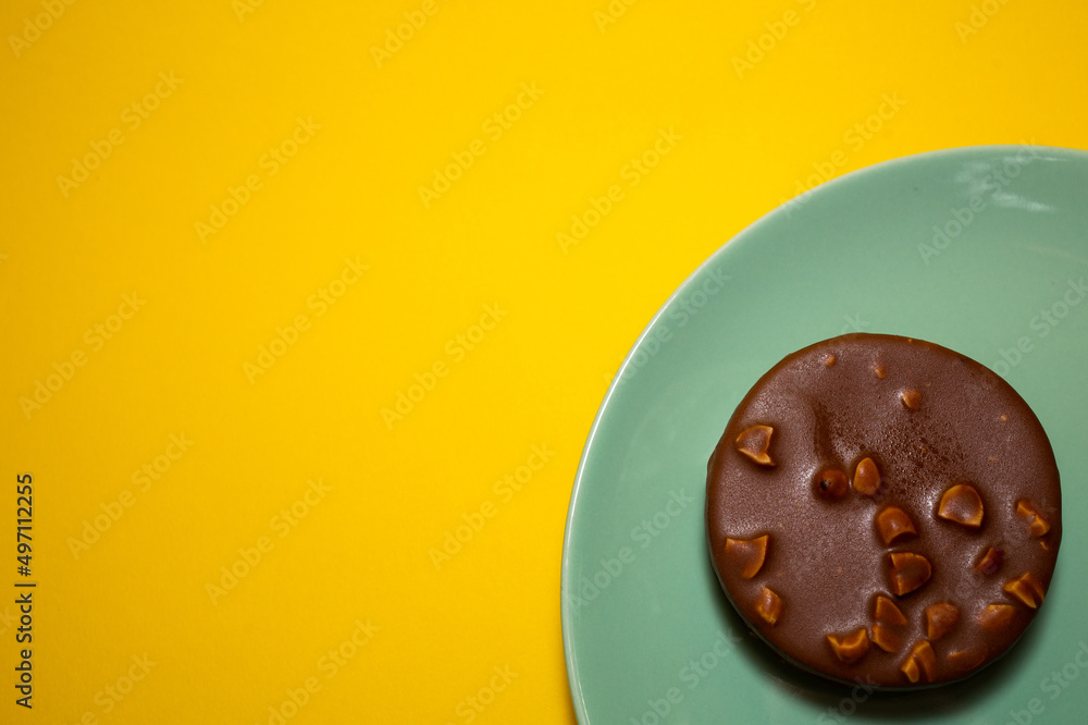 A picture of single homemade chocolate tart on yellow background. Same colour subject and background concept A picture of single homemade chocolate tart on yellow background. Same colour subject and background concept