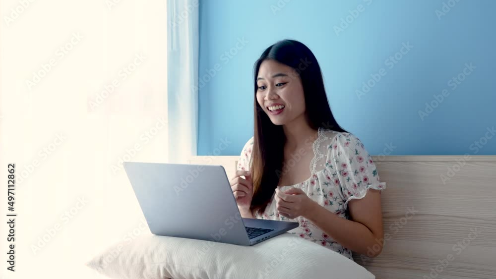 4K 50fps, Beautiful Asian girl, beautiful white floral shirt, sits and talks with supervisor on a laptop computer, through video call, with a comfortable expression on her face, working from home. 4K 50fps, Beautiful Asian girl, beautiful white floral shirt, sits and talks with supervisor on a laptop computer, through video call, with a comfortable expression on her face, working from home.