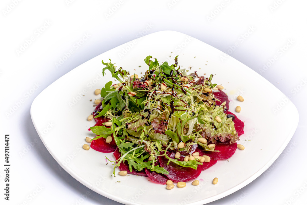 Beetroot salad, frieze salad and pine nuts with balsamic vinegar is on a plate Beetroot salad, frieze salad and pine nuts with balsamic vinegar is on a plate