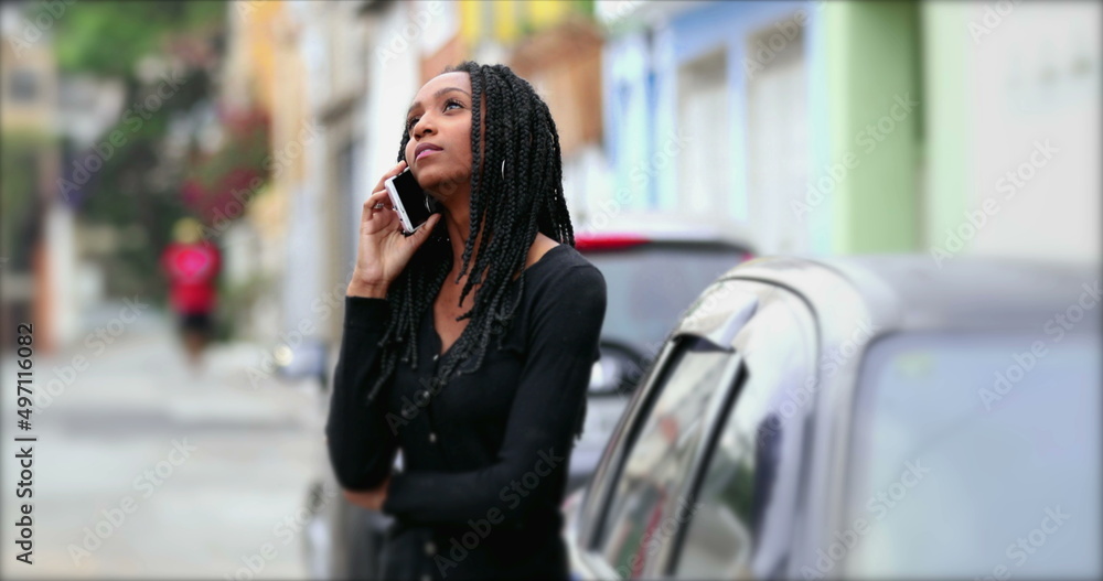 Teen girl talking on phone outside in street, adolescent teenager woman speaking on cellphone Teen girl talking on phone outside in street, adolescent teenager woman speaking on cellphone