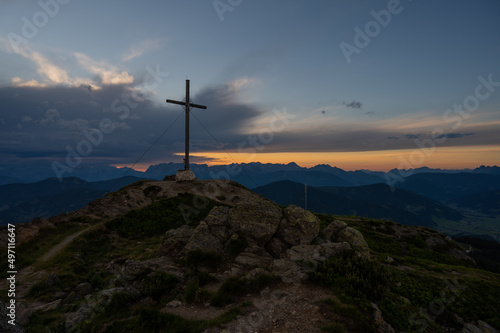 Sunset on the mountain with peak cross and wonderful clouds