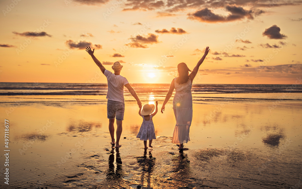 Fototapeta premium Family on the beach concept, Caucasian family playing and carrying his daughter on the tropical beach in sunset.