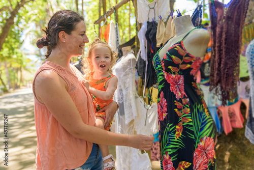 woman with baby shopping outdoors at typical traditional market photo