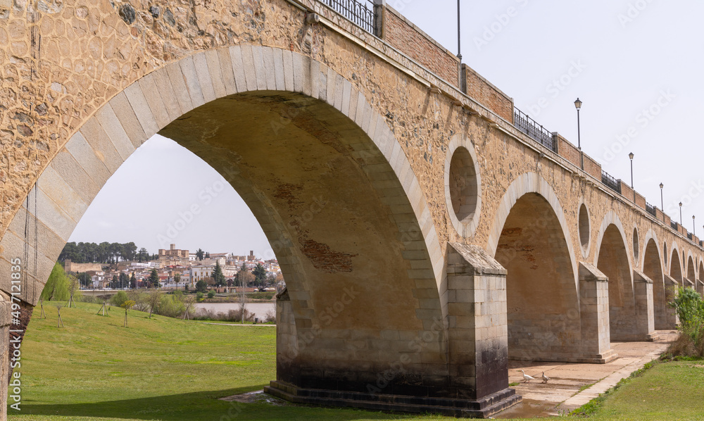 the historic 15-century Puente de Palmas Bridge with a view of the Old Town through one of the arches