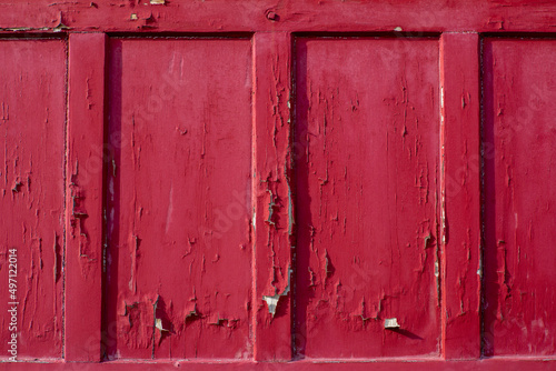 Red timber panel with paint peeling away