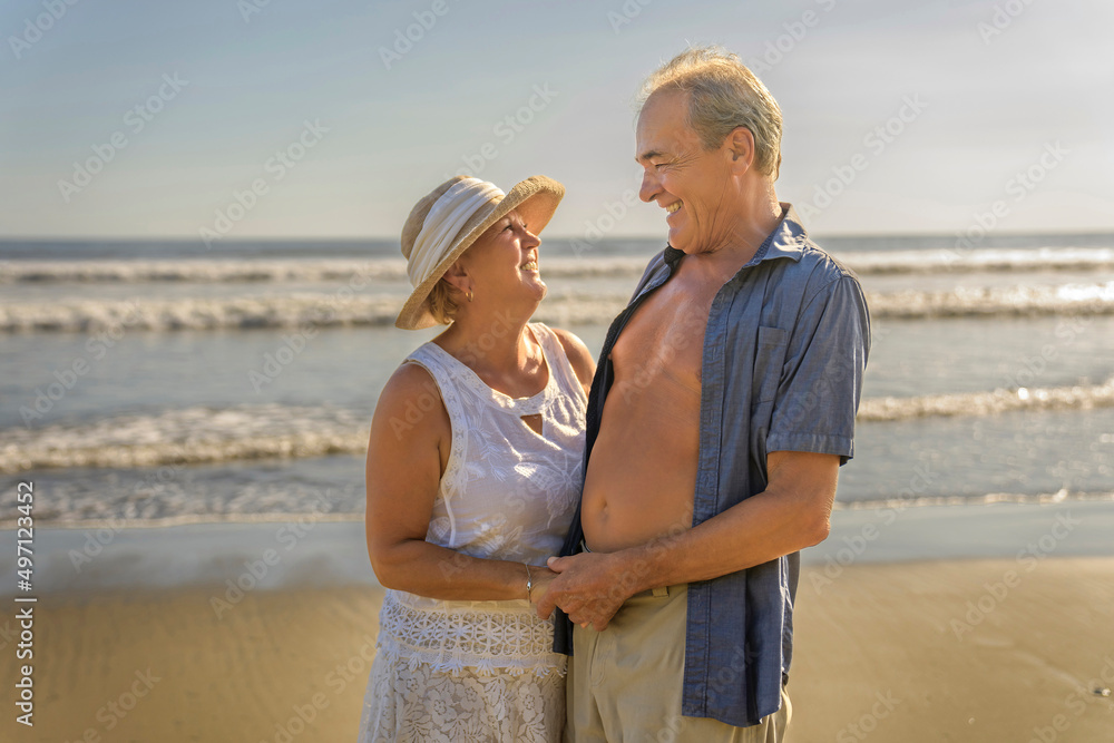Senior Couple Enjoying Beautiful Sunset on the Beach Senior Couple Enjoying Beautiful Sunset on the Beach