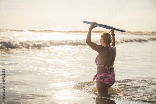 Photography woman with Boogie board on the beach at the sunset