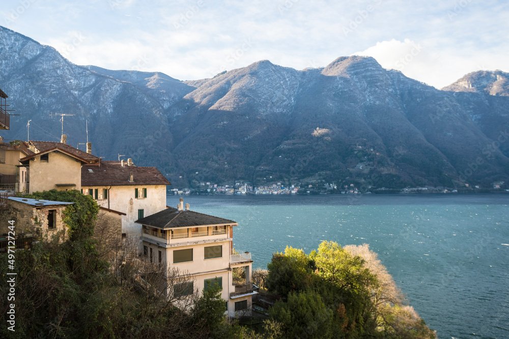 Italy, Como, Houses by lake Como with Alps in background Italy, Como, Houses by lake Como with Alps in background