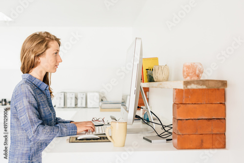 Young woman working from home on desktop pc