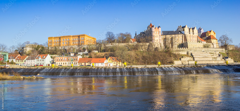 Panorama of the historic castle and old houses at the riverbank in Bernburg, Germany