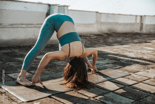 Woman Doing Yoga Outdoors On A Rooftop Terrace