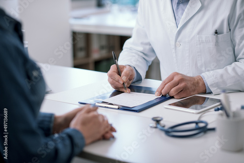 Doctor writing a medical prescription for his patient