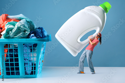 Obraz na płótnie Tiny woman holding laundry detergent