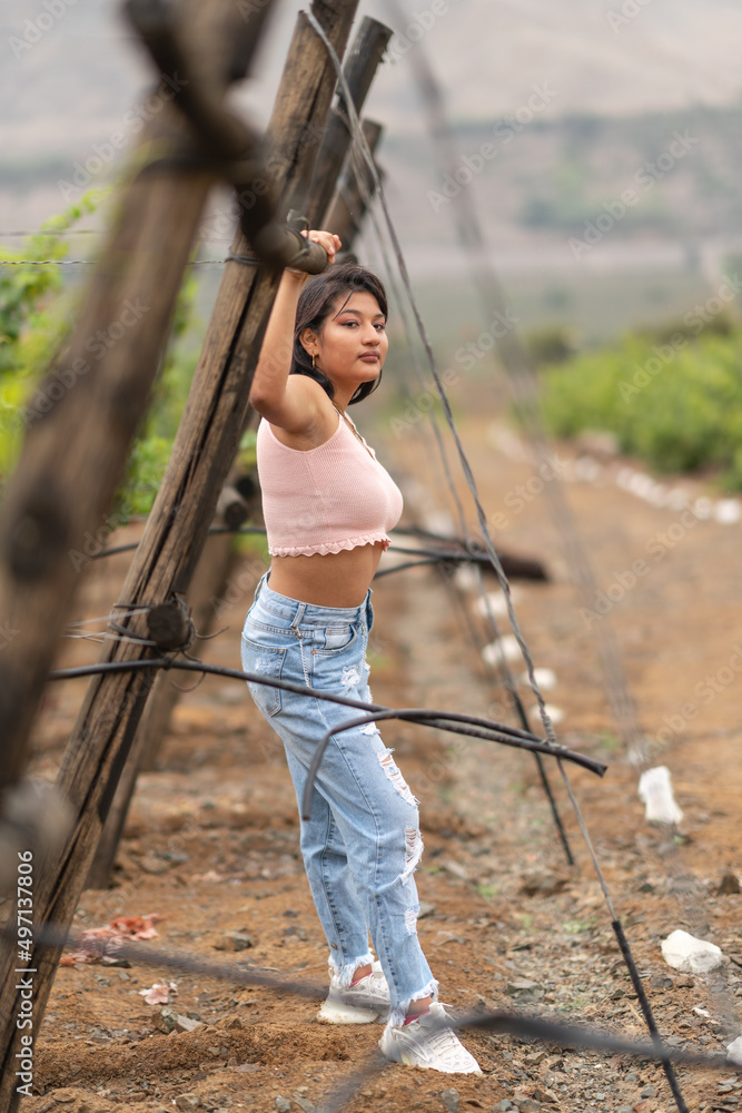 Young woman resting in front of a wooden vineyard structure Young woman resting in front of a wooden vineyard structure