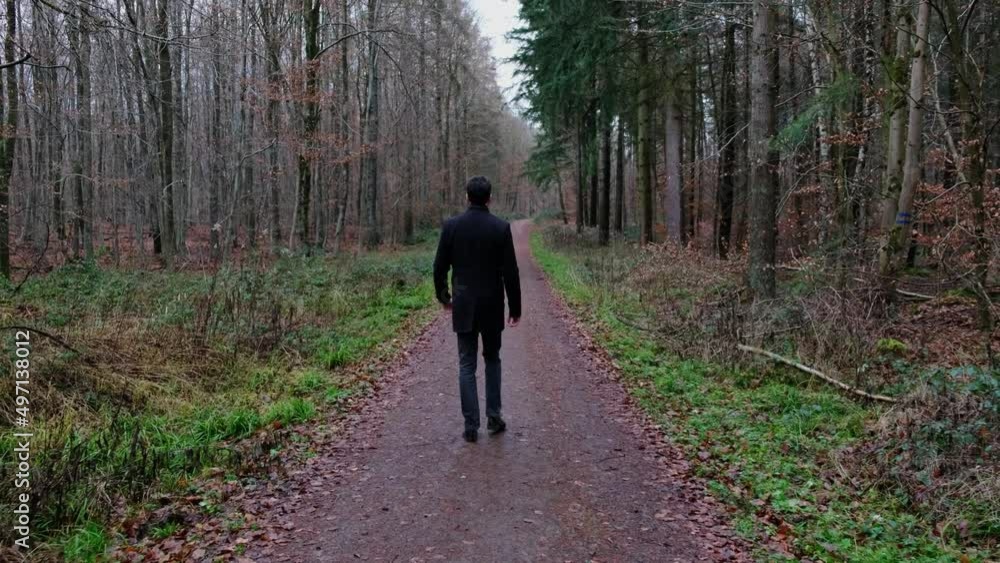 Man figure walking in a forest. Dark man in a woods. Man figure walking in a forest. Dark man in a woods.