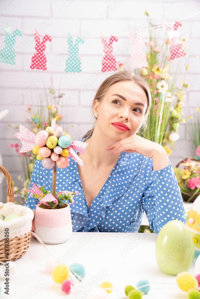 Pretty young women preparing easter decorations. Easter background. Bouquets of spring flowers. Easter eggs in baskets. Pretty young women preparing easter decorations. Easter background. Bouquets of spring flowers. Easter eggs in baskets.