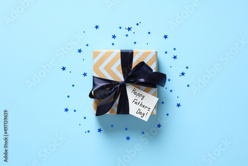 Happy Fathers Day gift with confetti on pastel blue background. Flat lay, top view.