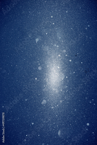 Snow blizzard texture , weather conditions with cold wind and snow, winter wind with snow on blue sky background, extreme weather conditions. Glitter and snow in the rays of light