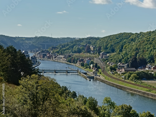 River Meuse with sluice, surrounded by hills with forests and houses on the embankments near the city of Dinant, Wallonia, Belgium 