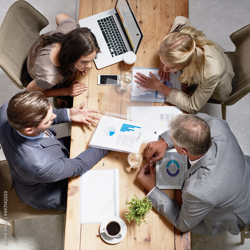 Looking through ways to build their business. High angle shot of a group of businesspeople having a discussion in an office. Looking through ways to build their business. High angle shot of a group of businesspeople having a discussion in an office.
