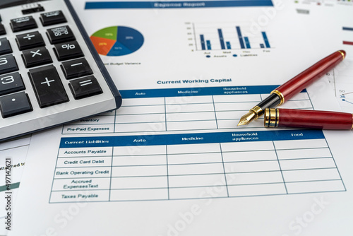 Annual financial document data charts with calculator pen on desk © RomanR