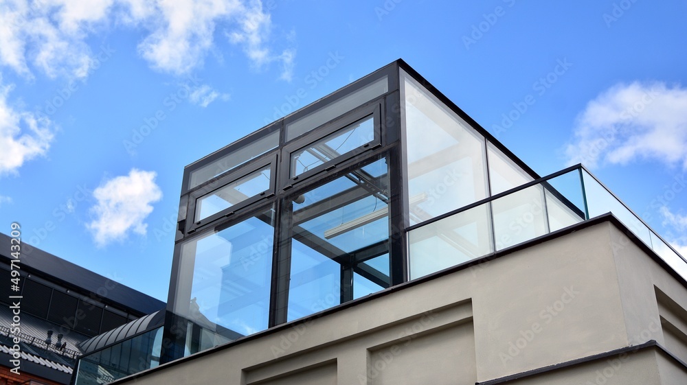 Modern office building with glass facade on a clear sky background. Abstract close up of the glass-clad facade of a modern building covered in reflective plate glass. Modern office building with glass facade on a clear sky background. Abstract close up of the glass-clad facade of a modern building covered in reflective plate glass.