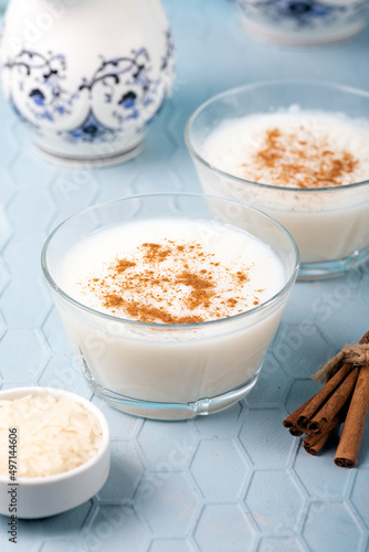 Creamy rice pudding in bowls. Creamy rice pudding topped with cinnamon on blue background.