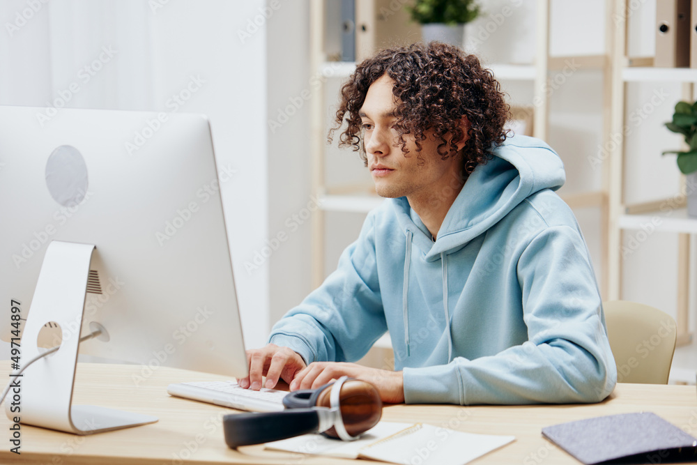 guy with curly hair sitting in front of the computer internet online technologies guy with curly hair sitting in front of the computer internet online technologies