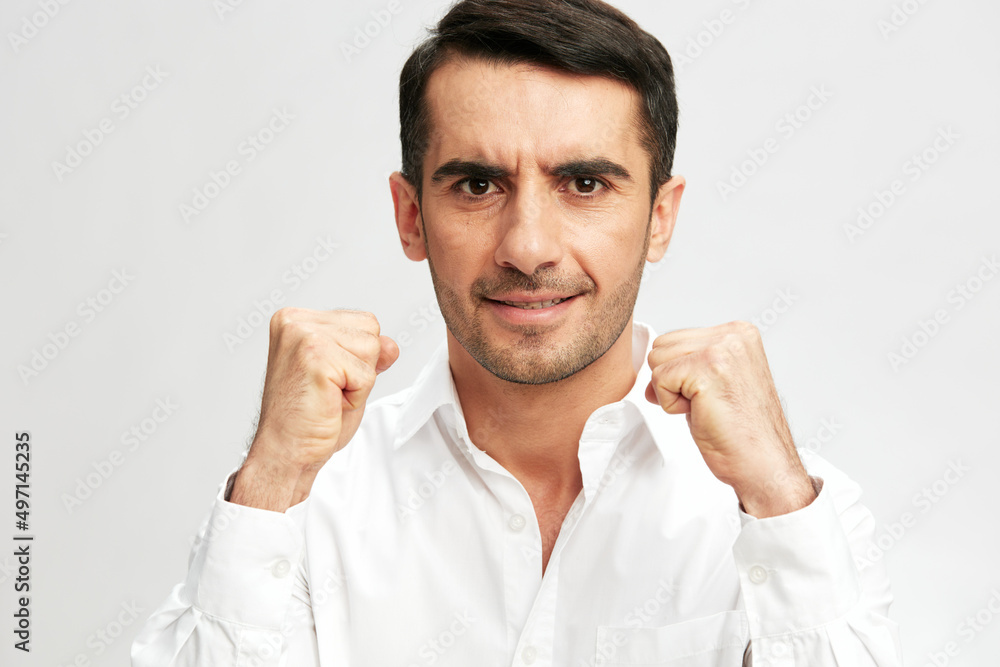 handsome businessman white shirt posing holding fists in front of him emotions light background handsome businessman white shirt posing holding fists in front of him emotions light background