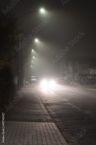 car driving on city road in dark and foggy night