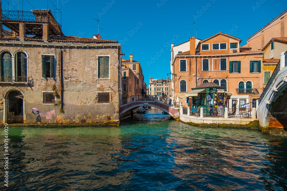 View of people crossing the bridge over the beautiful canals of Venice