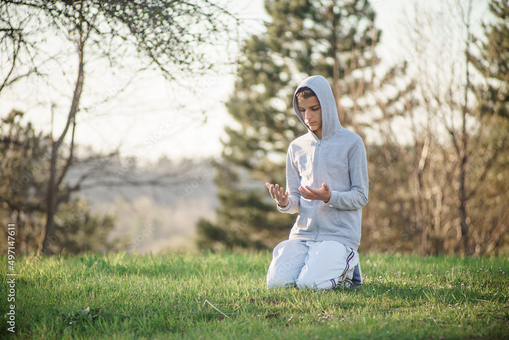 Fototapeta premium Muslim young man prays outdoor, the holy month of Ramadan