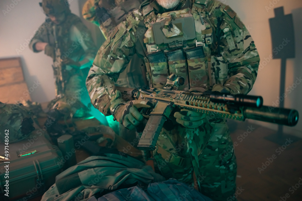 Fototapeta premium Cropped image of men in military equipment. Men in uniforms holding machine gun. Military, army, airsoft concept